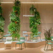 Design kantoormeubilair: Pedrali Souvenir stoelen met en zonder armleggers, groene plantenwand