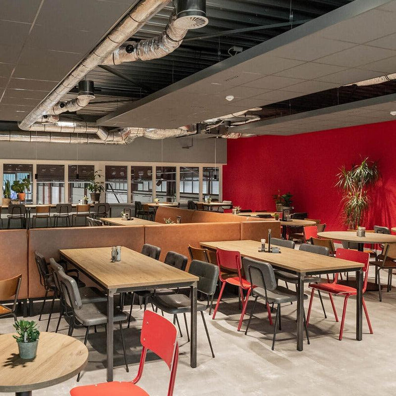 Moderne kantine met design kantoormeubels, houten tafels en satellietstoelen, rode accentmuur