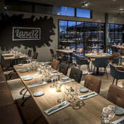 Moderne restaurantinrichting met design kantoormeubels, houten tafels en stijlvolle stoelen.