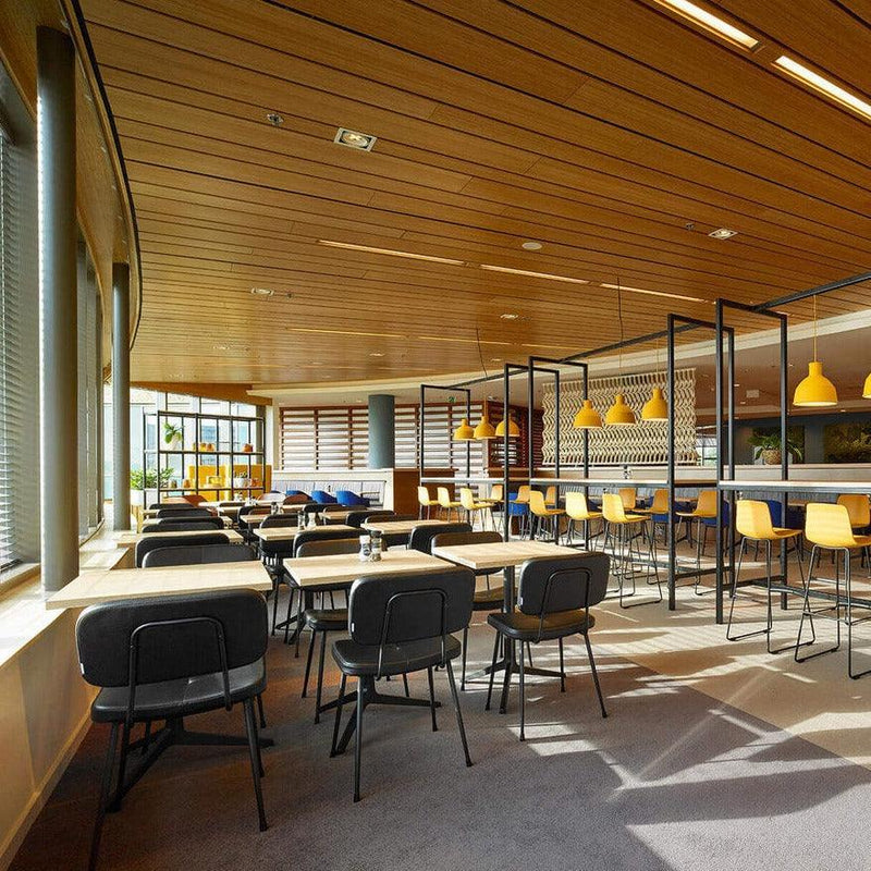 Moderne kantoorruimte met design kantoormeubilair, houten tafels en gele vergaderstoelen.