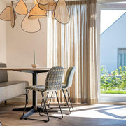 Moderne design stoel en tafel in lichte kantoorruimte met grote ramen en hanglamp, kantoormeubels online
