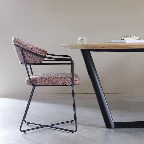 Design vergaderstoel met metalen frame en bekleding naast houten bureau in moderne kantoorruimte