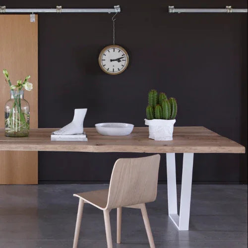 Houten vergadertafel met design stoel, planten en klok, kantoormeubilair inspiratie