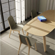 Design vergadertafel met lichte houten poten en drie moderne stoelen in kantoorruimte