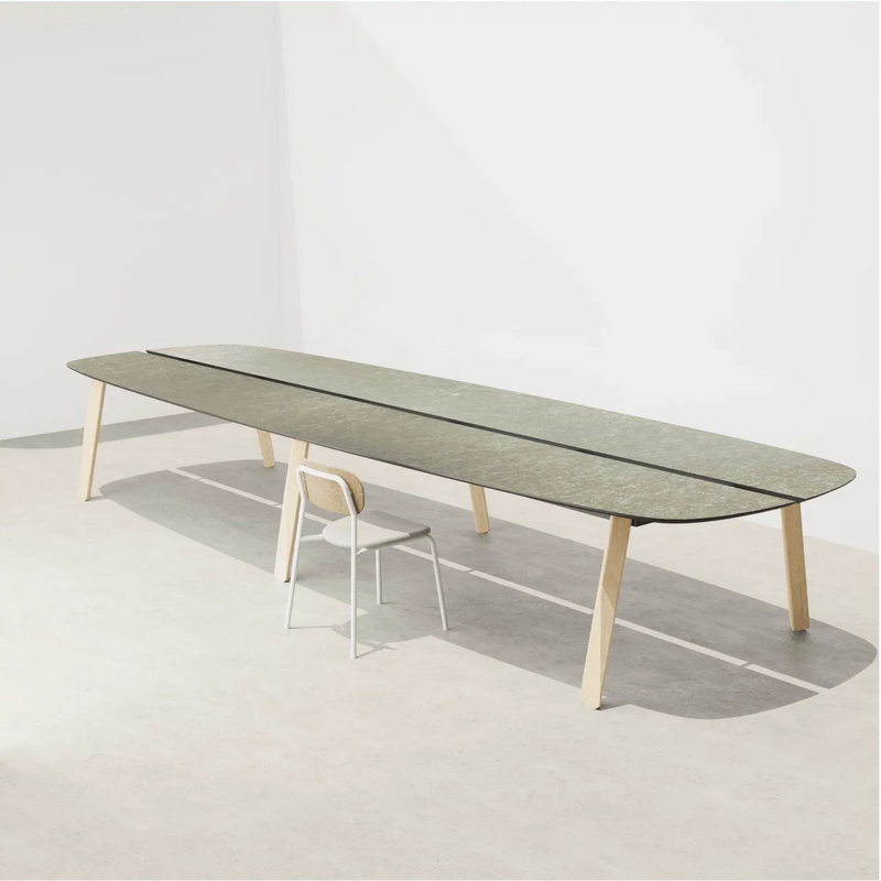 Design vergadertafel met groene blad en houten poten, moderne kantoorstoel erbij, kantoormeubilair