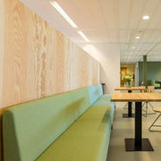 Groene treinbank in moderne kantoorruimte met houten tafels, kantoormeubilair design