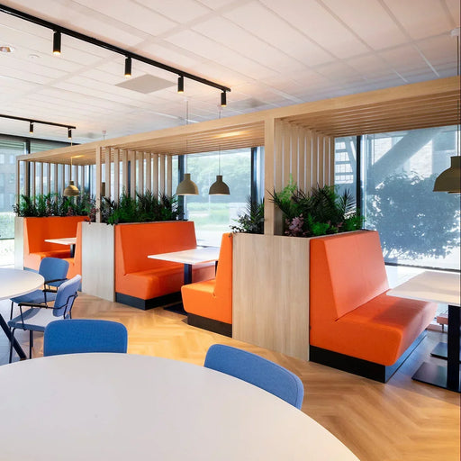 Moderne kantoorinrichting met oranje treinbanken, houten wanden en veel daglicht. Een project van Kantoormeubels.online.