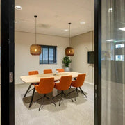 Moderne Bridge vergadertafel met oranje stoelen in design kantoor, kantoormeubilair online