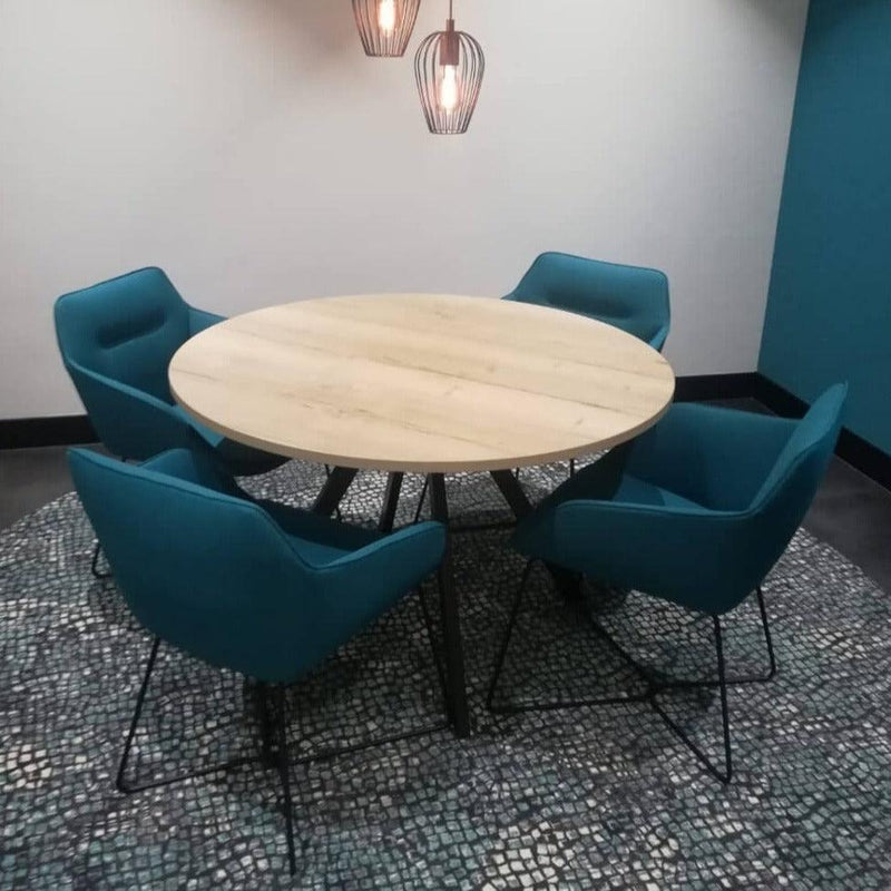 Bridge ronde vergadertafel met houten blad en zwart frame, met vier blauwe stoelen in moderne kantoorruimte.