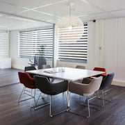 Bridge vierkante witte tafel met gekleurde stoelen in moderne kantoorruimte met groot raam en spiegelwand