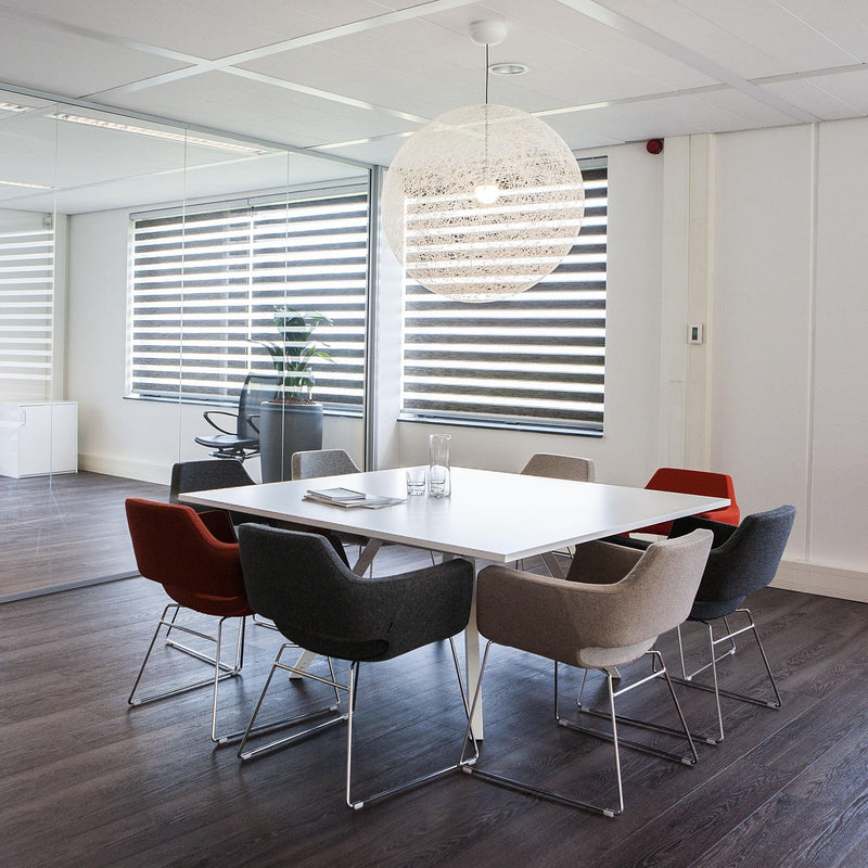 Bridge vierkante witte tafel met gekleurde stoelen in moderne kantoorruimte met groot raam en spiegelwand