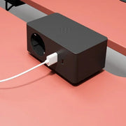 Zwarte bureau stekkerdoos met USB poort op modern rood kantoorblad, kantoormeubilair