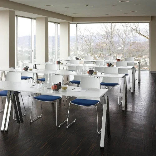 Moderne vergaderruimte met design kantoormeubilair, witte tafels en stoelen, veel lichtinval