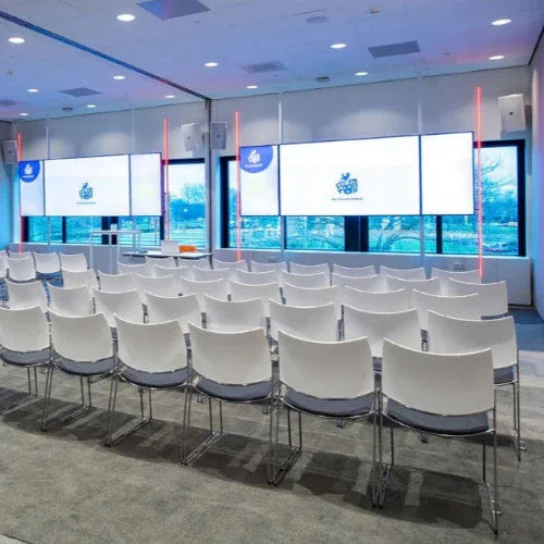 Moderne vergaderruimte met witte conferentiestoelen en grote schermen, kantoormeubilair